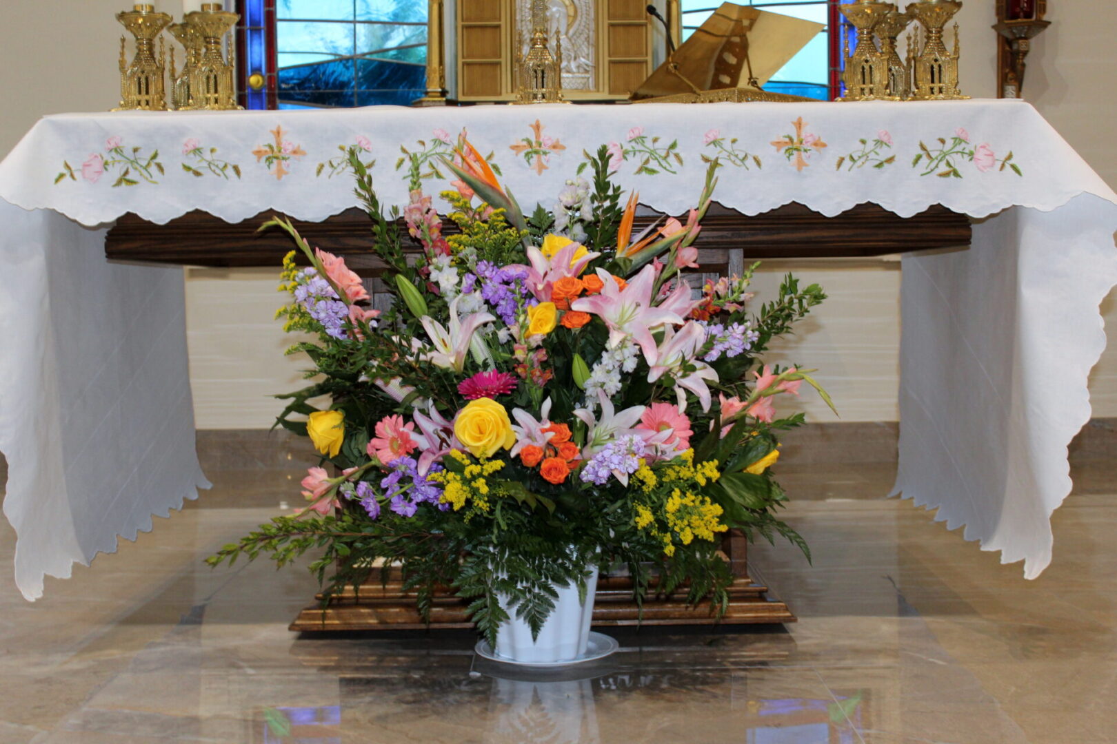 A vase of colorful flowers in front of the altar