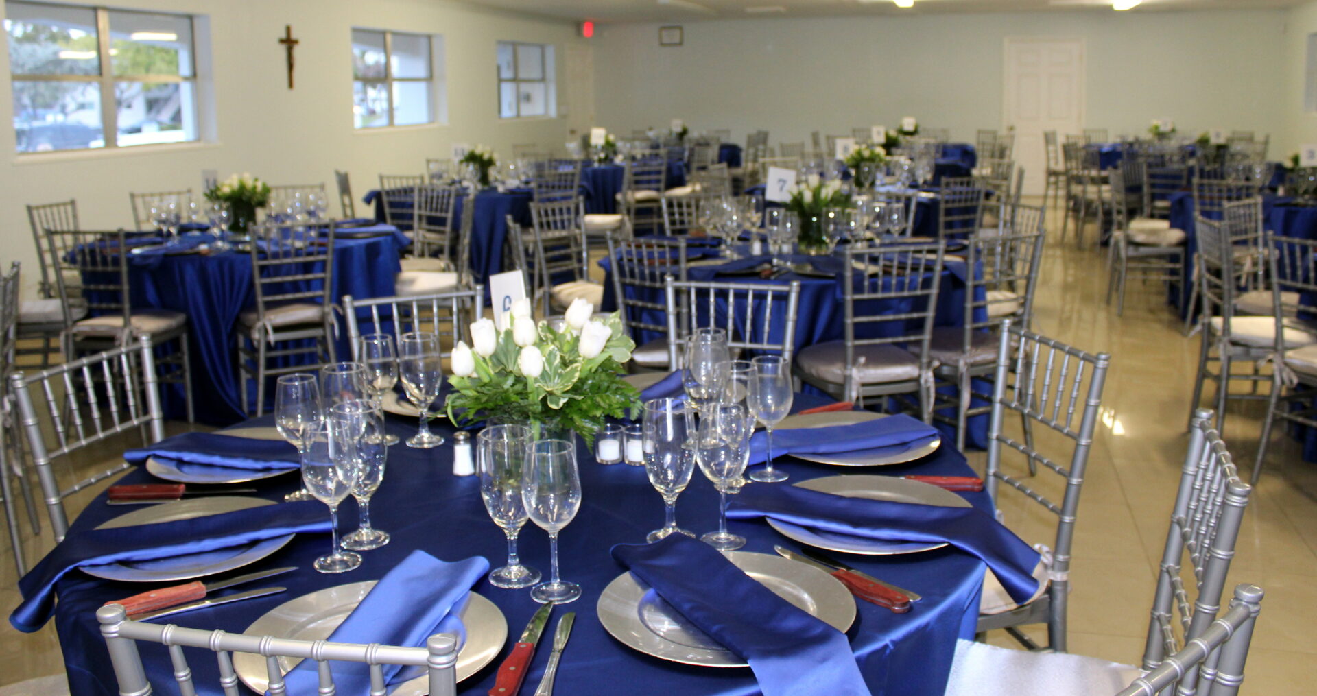 A room with empty tables and chairs with blue table setup