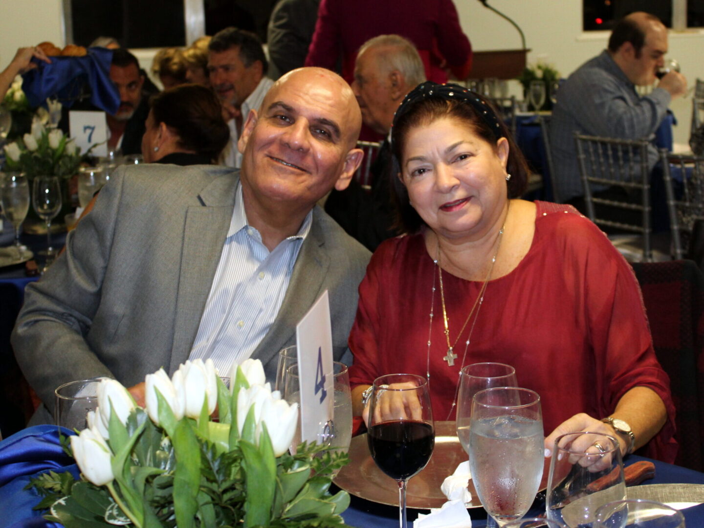 A man wearing a gray suit and a woman wearing a red top