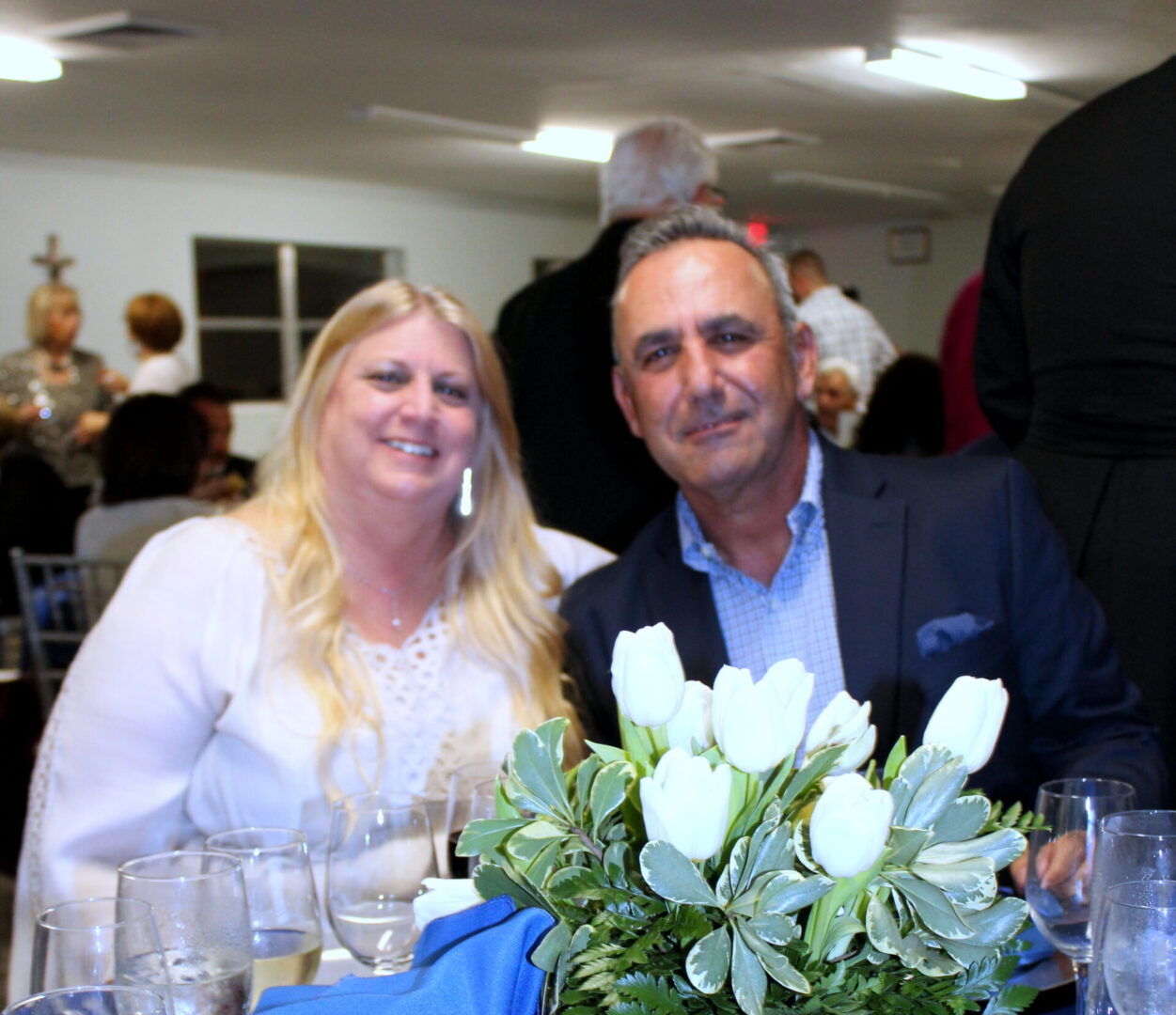 A man wearing a blue suit and a woman wearing a white top