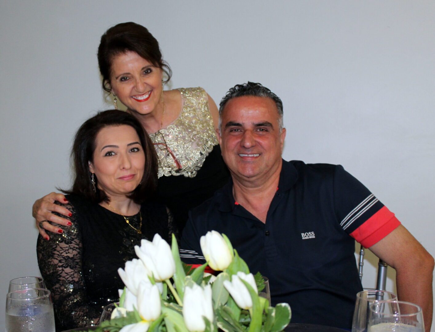 Two women and a man wearing a blue polo shirt