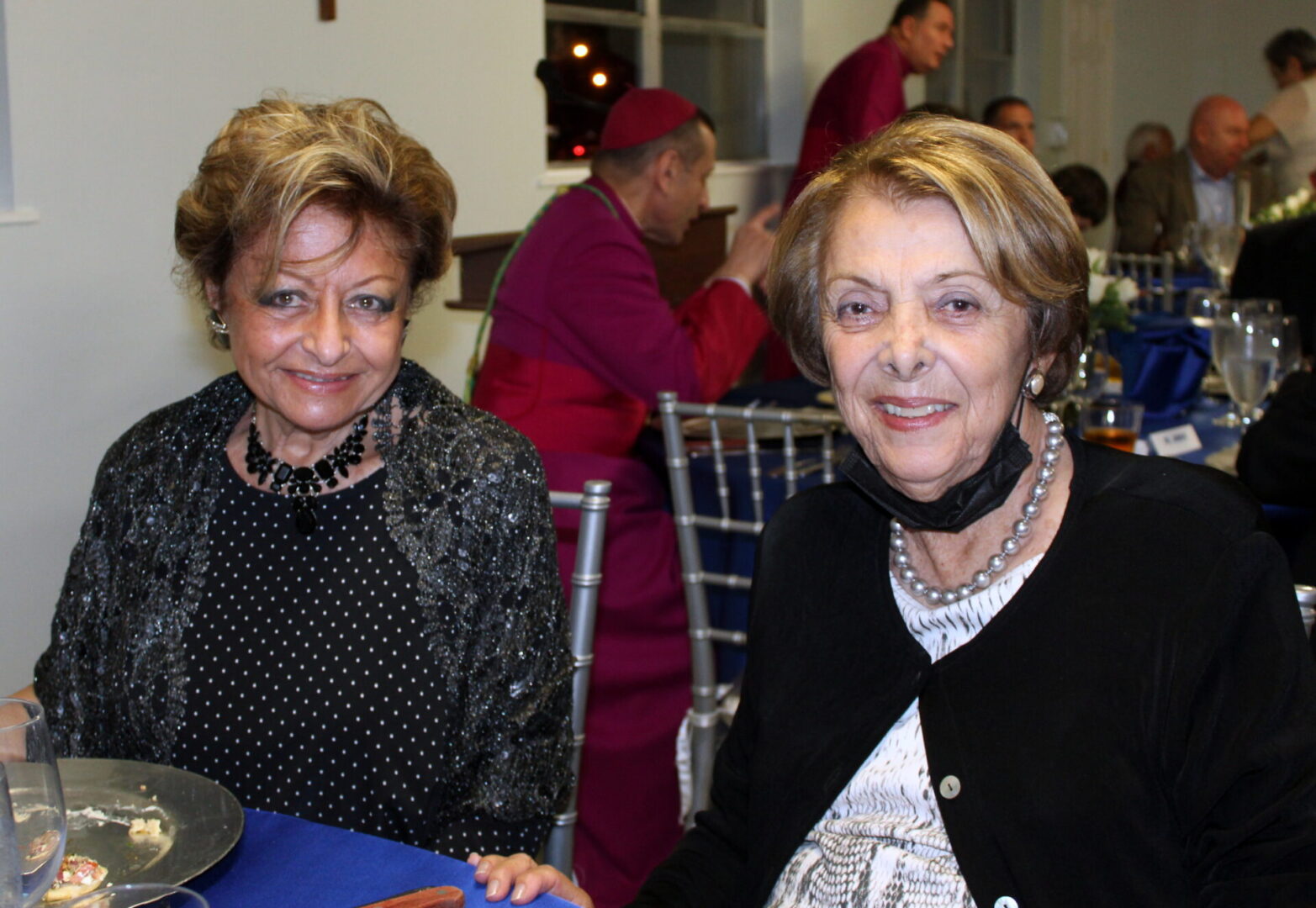 Two old women wearing black and white pearls