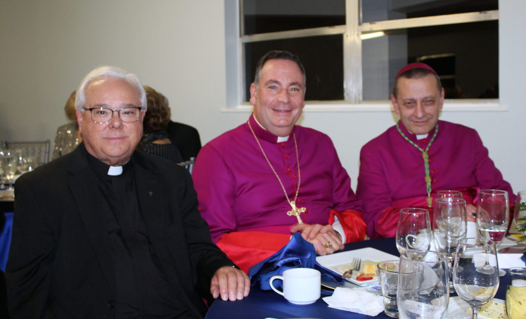 Three church personnel; two were wearing purple uniform and the other one was wearing a black suit