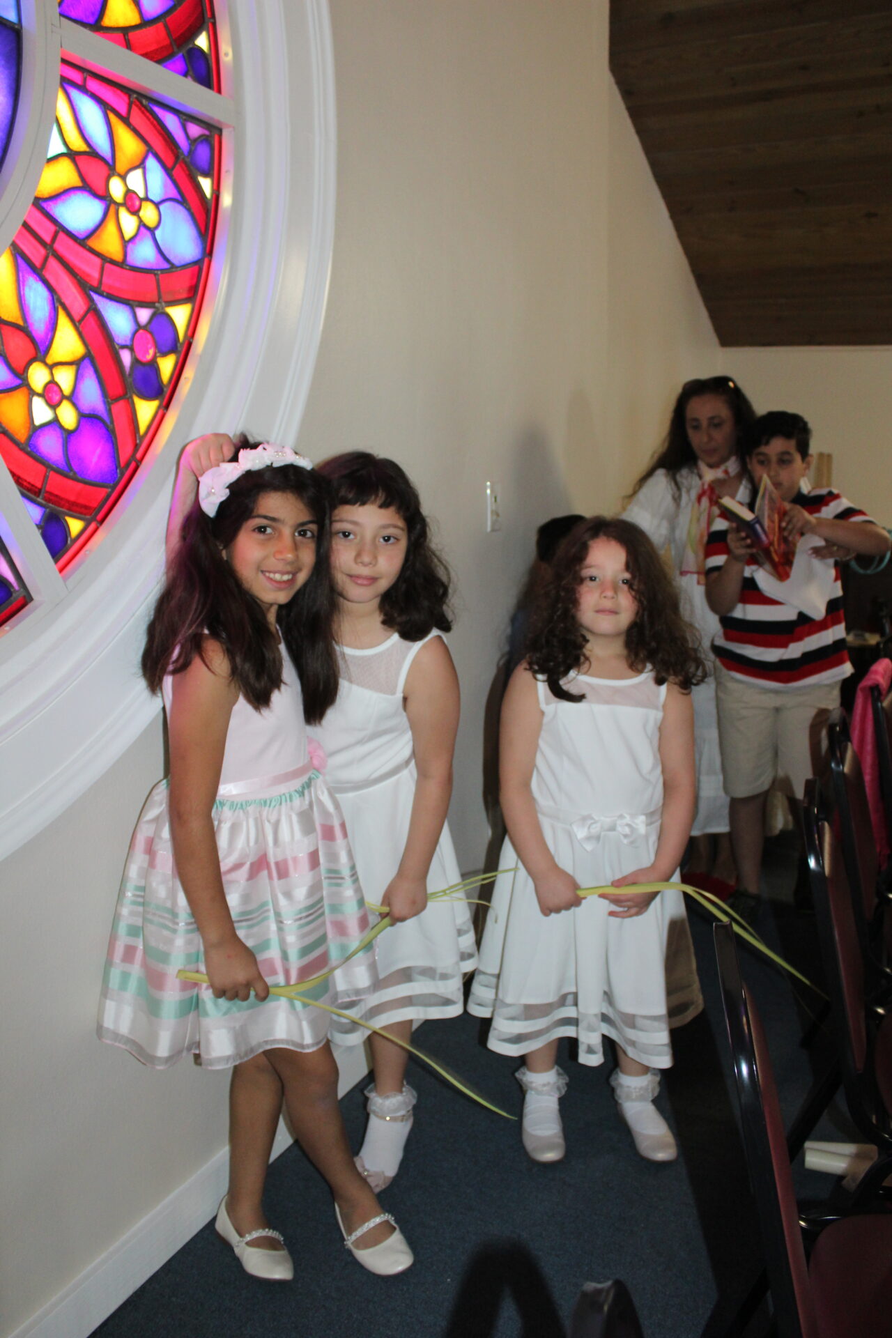 Three girls wearing white dresses