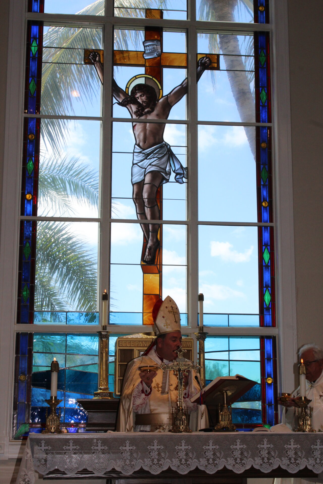 A bishop while holding a gold plate at the altar