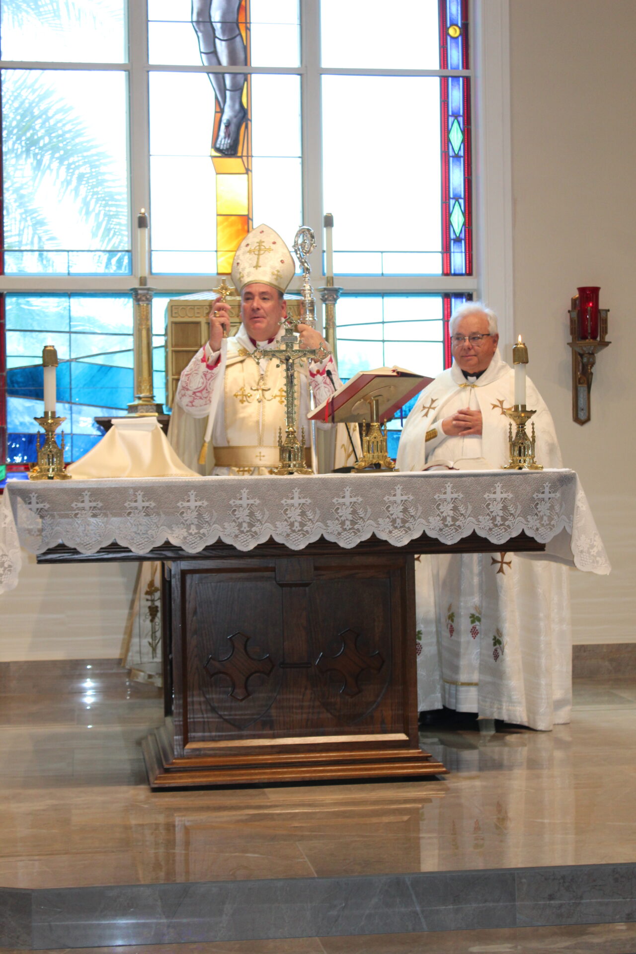 The bishop holding a gold cross and a chalice