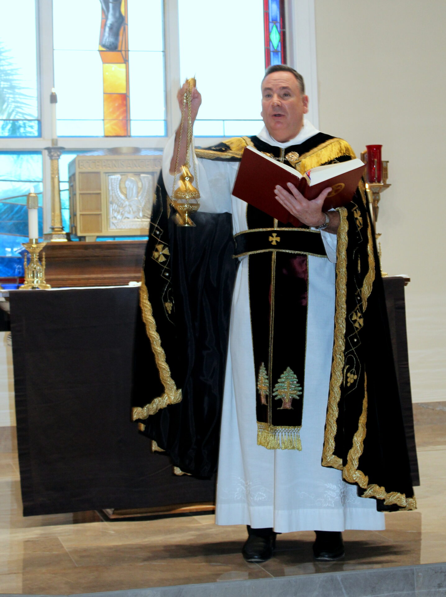 A priest holding a red book