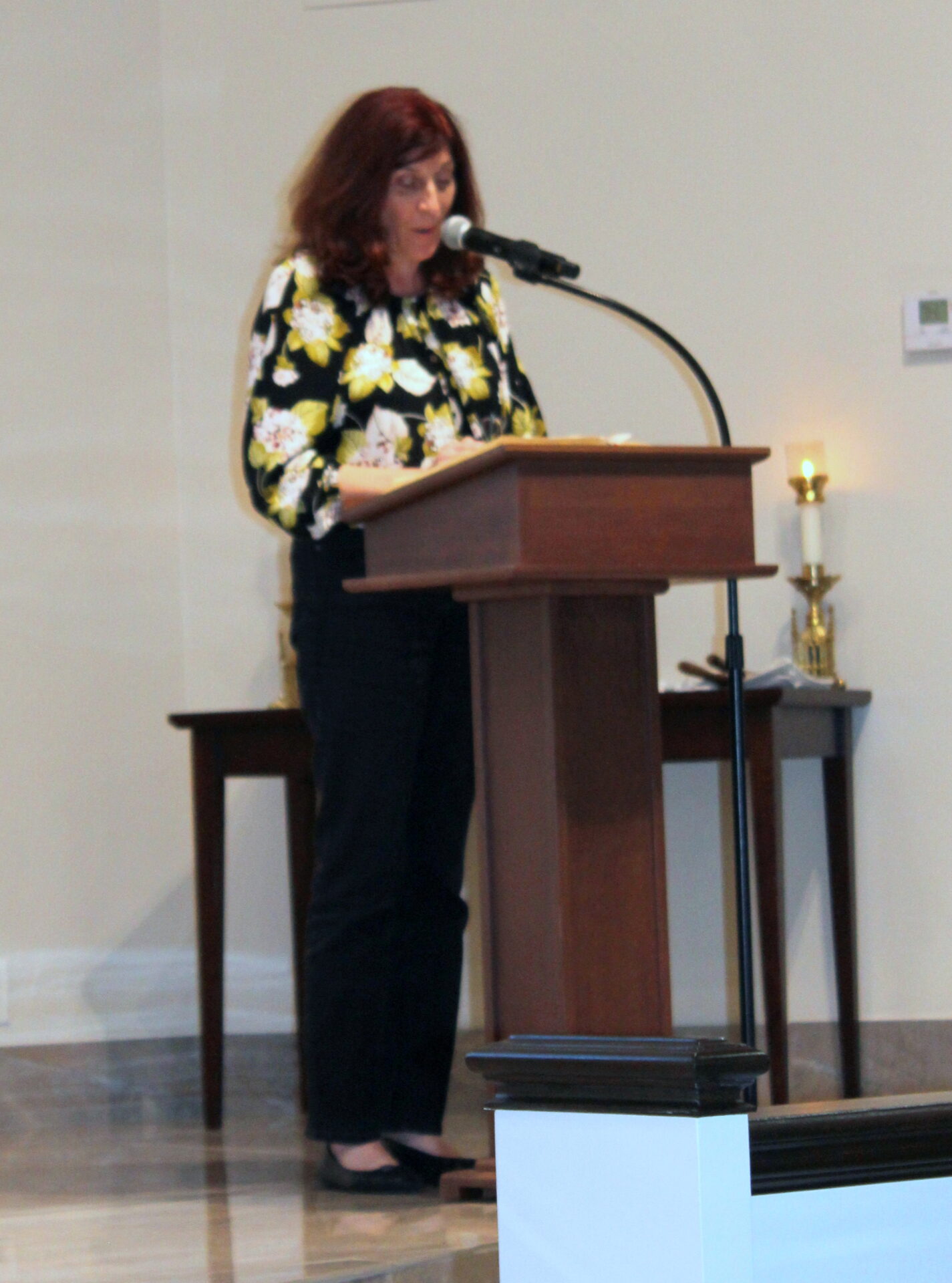 A woman wearing a top with black, yellow, and white designs and a black pants