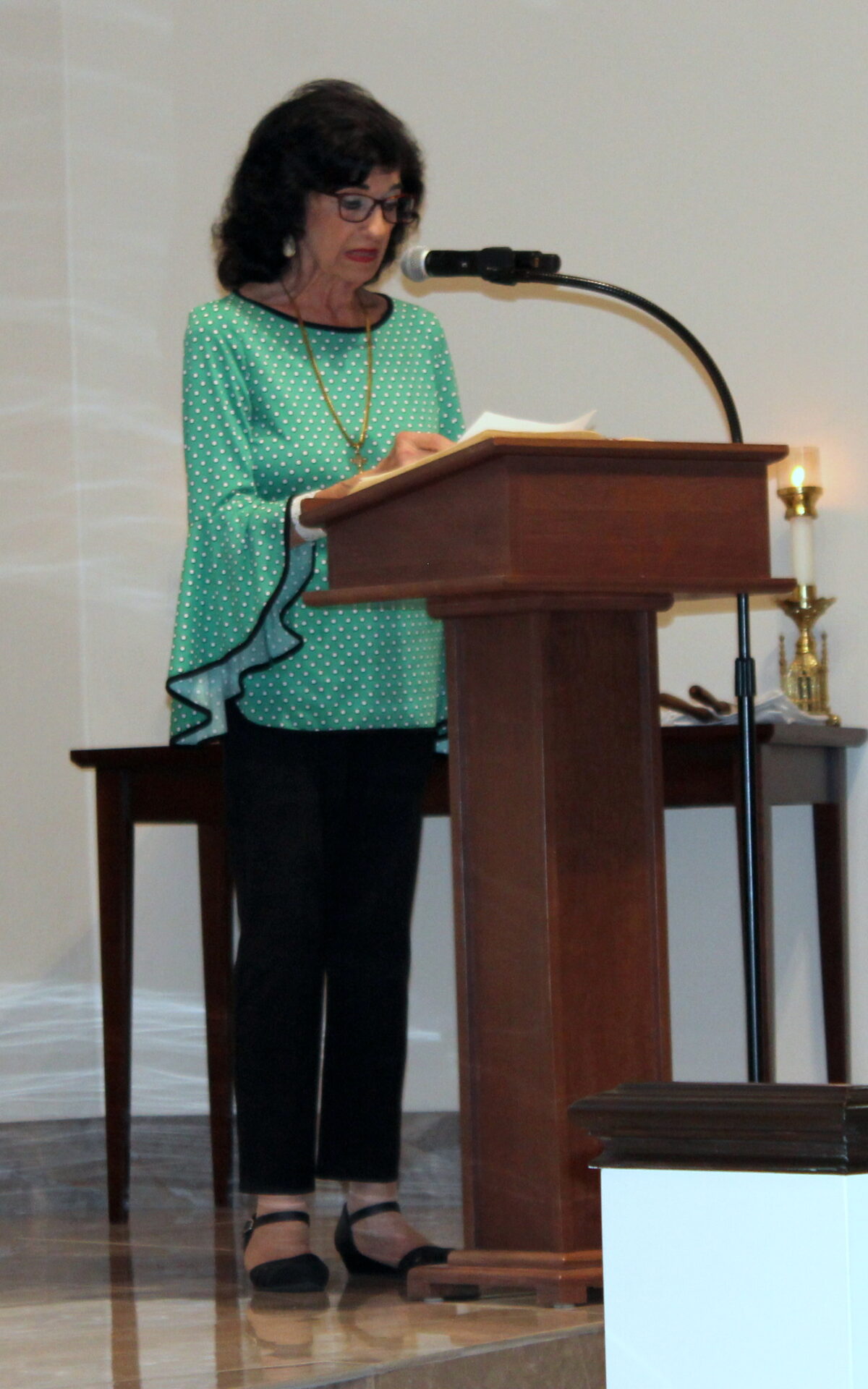 A woman wearing a light-green top with polka dots design