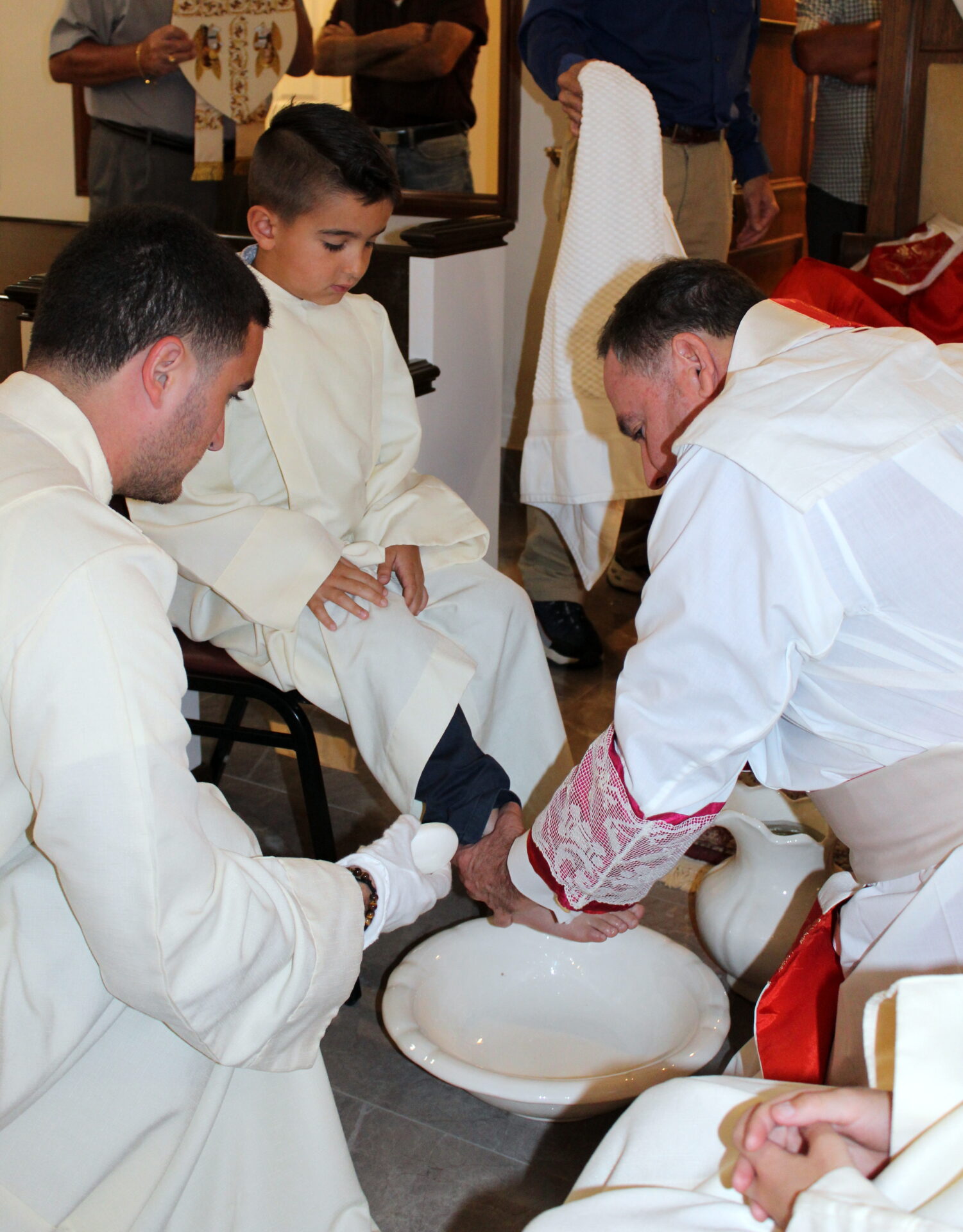 A priest washing a young sacristan’s feet