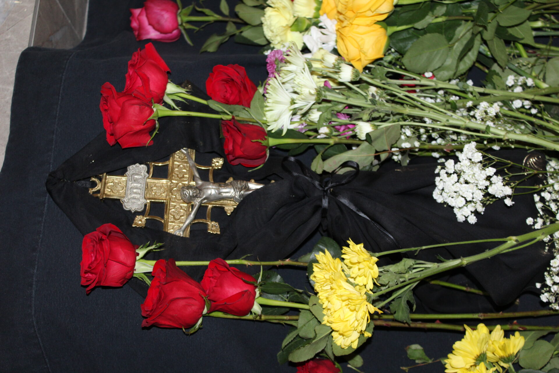 A bunch of flowers with the cross wrapped with black fabric
