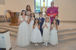 A group of kids wearing their first communion dress