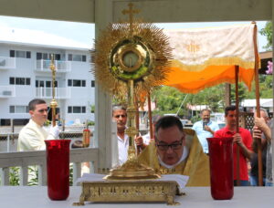 A gold Monstrance with red candles on its side